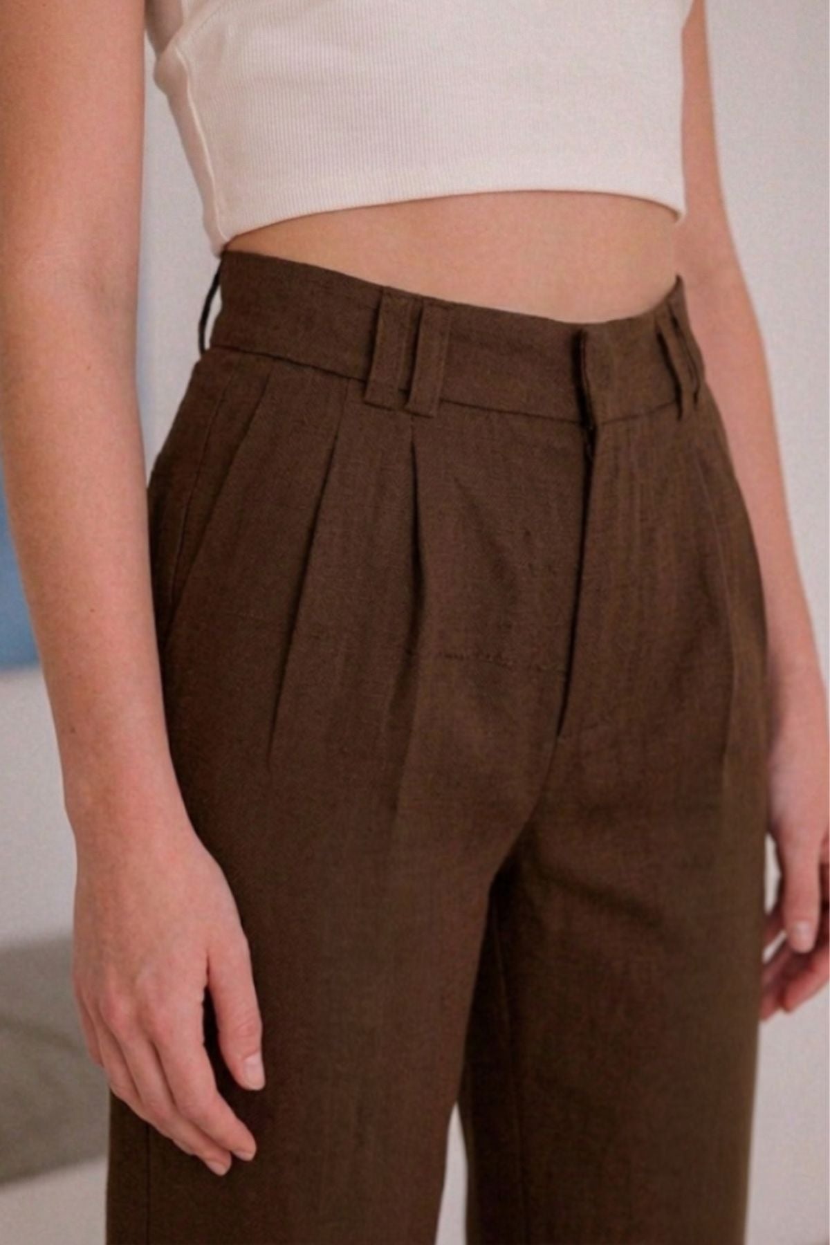 Calça Alfaiataria Slim Linho Marrom com detalhe de pregas, ideal para um visual sofisticado e confortável.