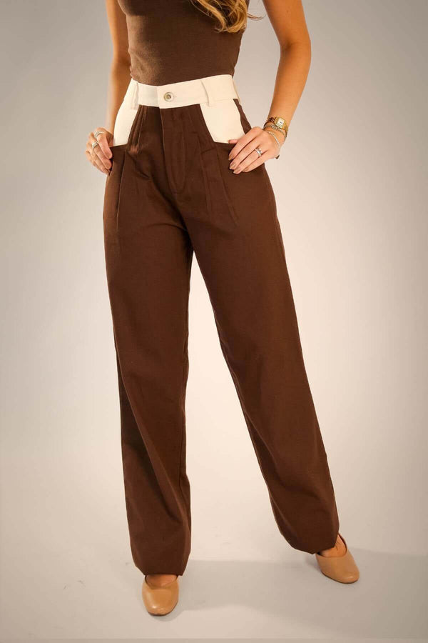 Calça alfaiataria marrom com recorte no bolso diagonal, confeccionada em 100% algodão, ideal para qualquer ocasião.