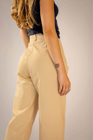 Calça Alfaiataria Reta Bege vista lateral com recorte no bolso diagonal e caimento perfeito.